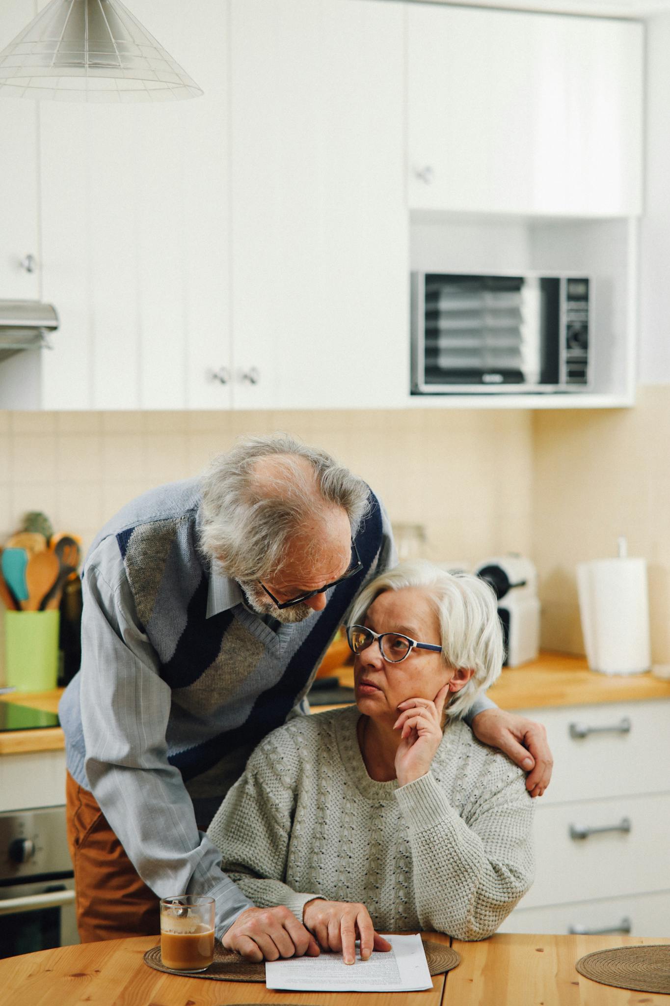Senior couple discussing paperwork at home, fostering communication.
